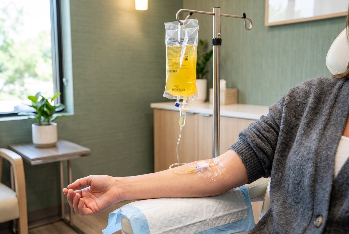 Cliënt tijdens een vitamine infuus in een behandelkamer van Neo Clinics