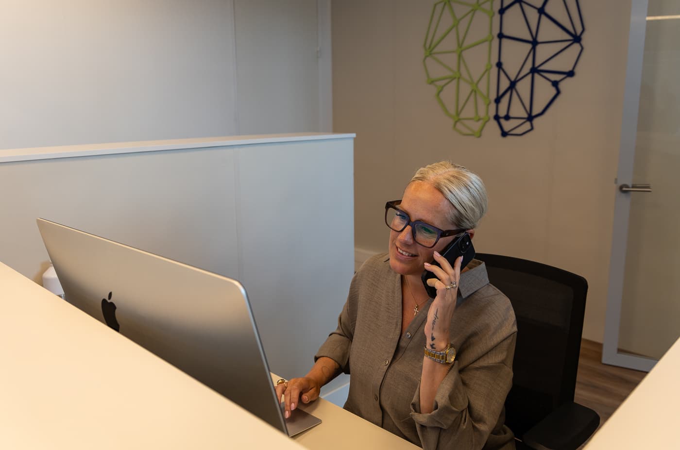 Een medewerker van Neo Clinics aan de telefoon bij de balie